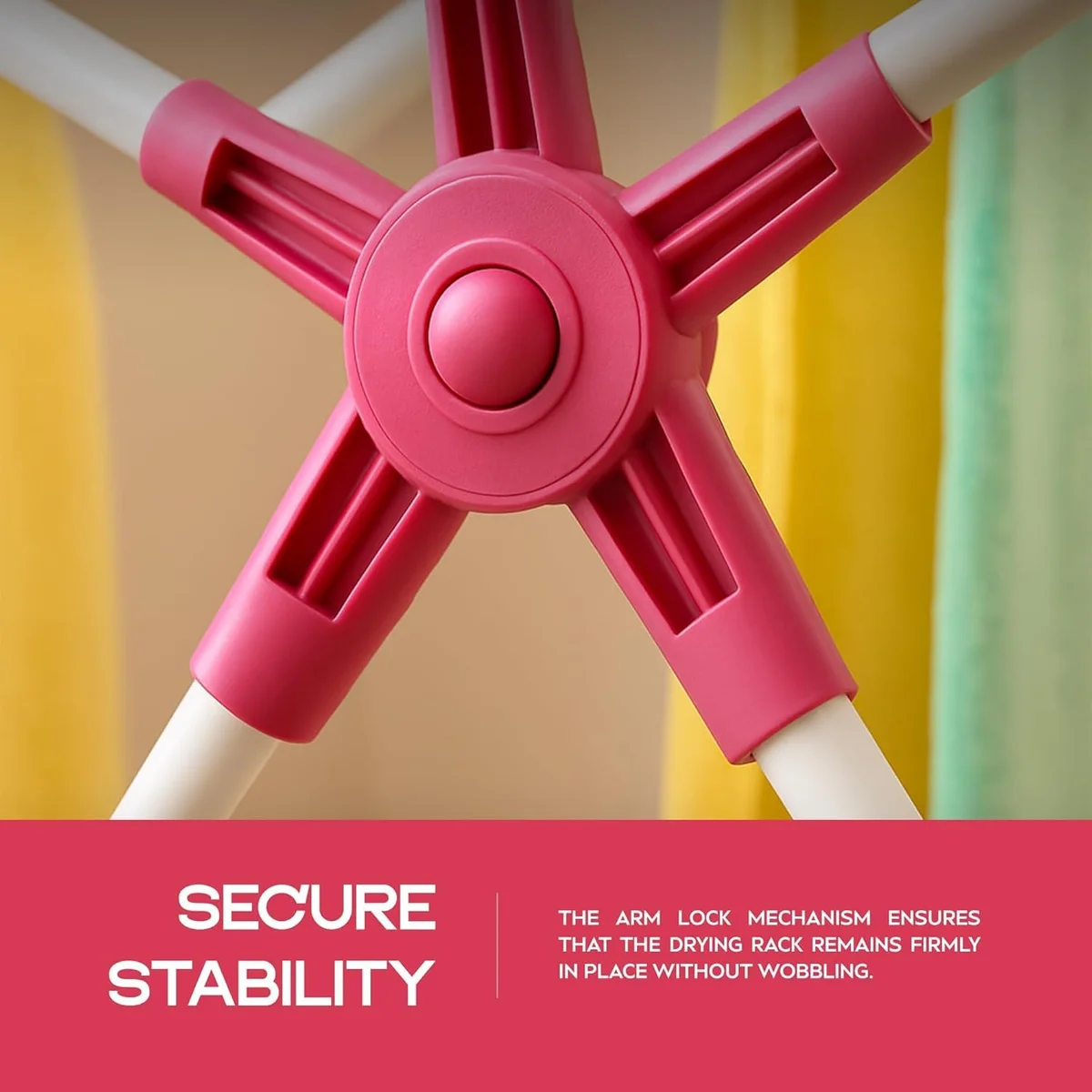 Foldable portable laundry rack in white and pink stainless steel with three tiers and non-slip feet on wooden floor