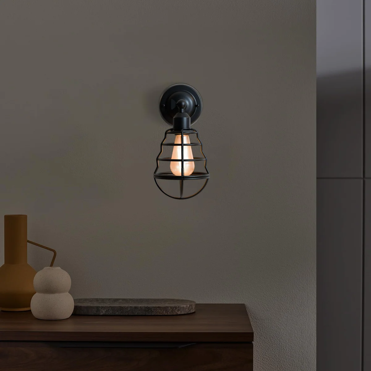 Adjustable industrial wall sconce with vintage balloon-shaped metal cage and E27 bulb holder mounted on white wall
