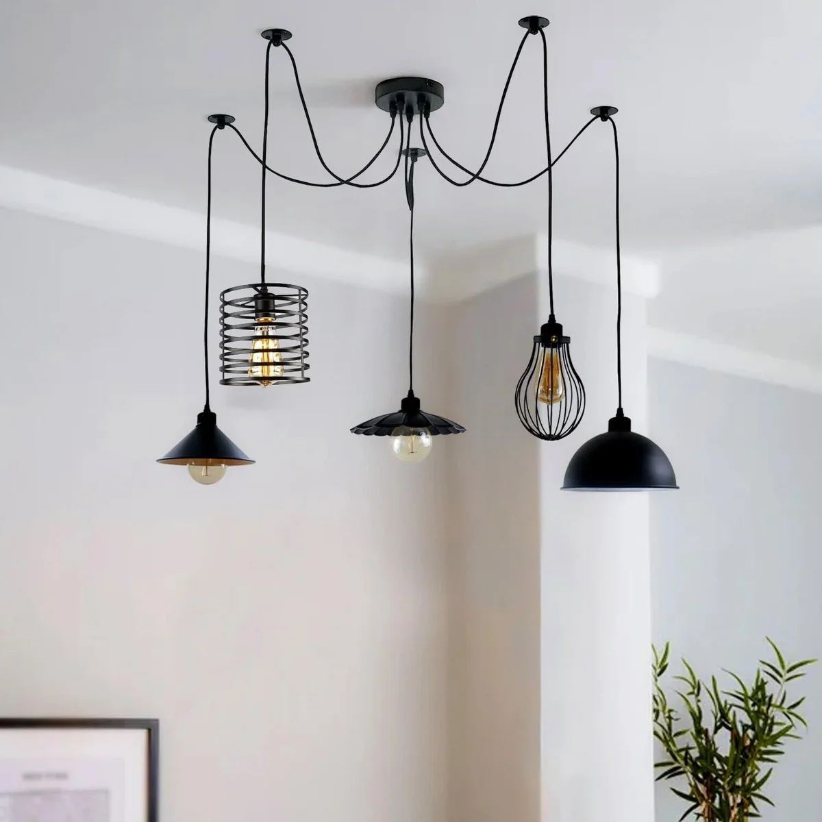 Vintage industrial light with five metal cage pendant shades hanging from a round ceiling plate, adjustable cables visible