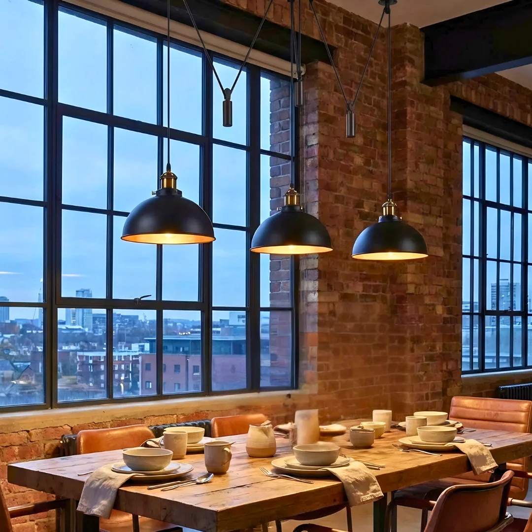 Vintage pendant light with three black metal shades and gold interiors, ceiling-mounted industrial style fixture