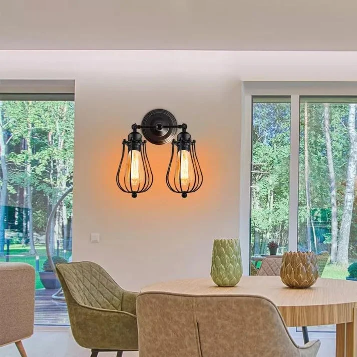 Industrial wall sconce with dual E27 cage lamps, black metal finish, and circular decorative backplate mounted on wall