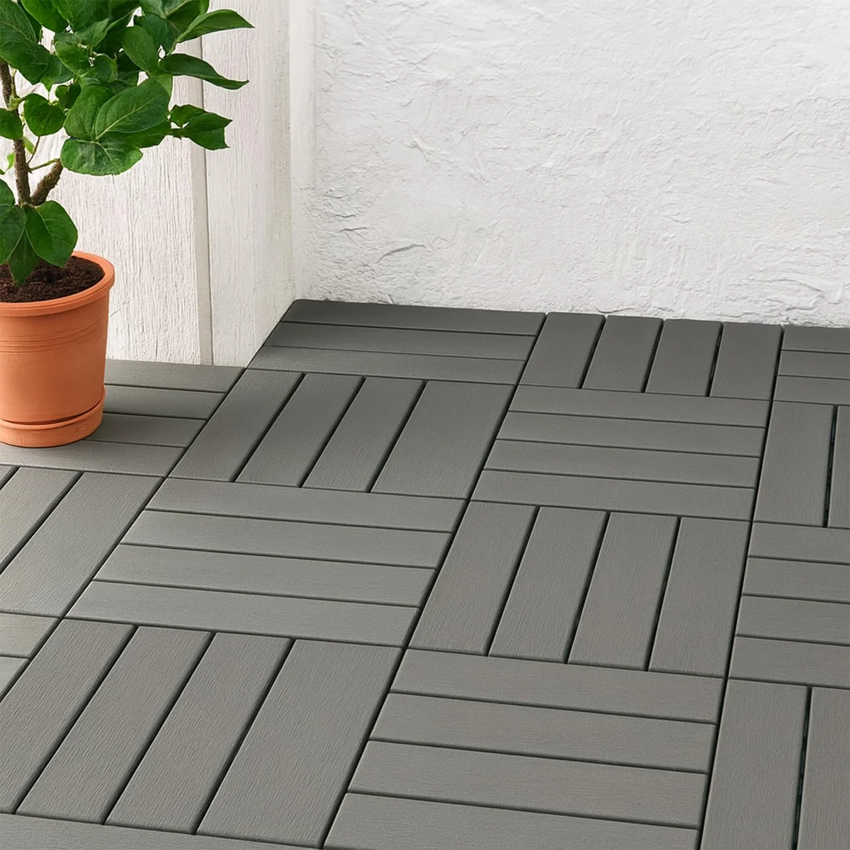 Anthracite interlocking patio tiles installed on outdoor patio, showing snap-lock system and slat pattern design