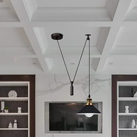 Black metal ceiling lamp with pulley wheels and long cable, designed for soft ambient lighting in industrial style rooms