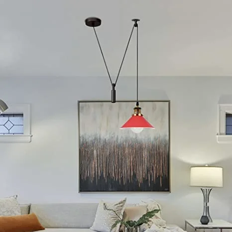 Black industrial space-saving ceiling light fixture with pulley wheels and long cable hanging from ceiling plate