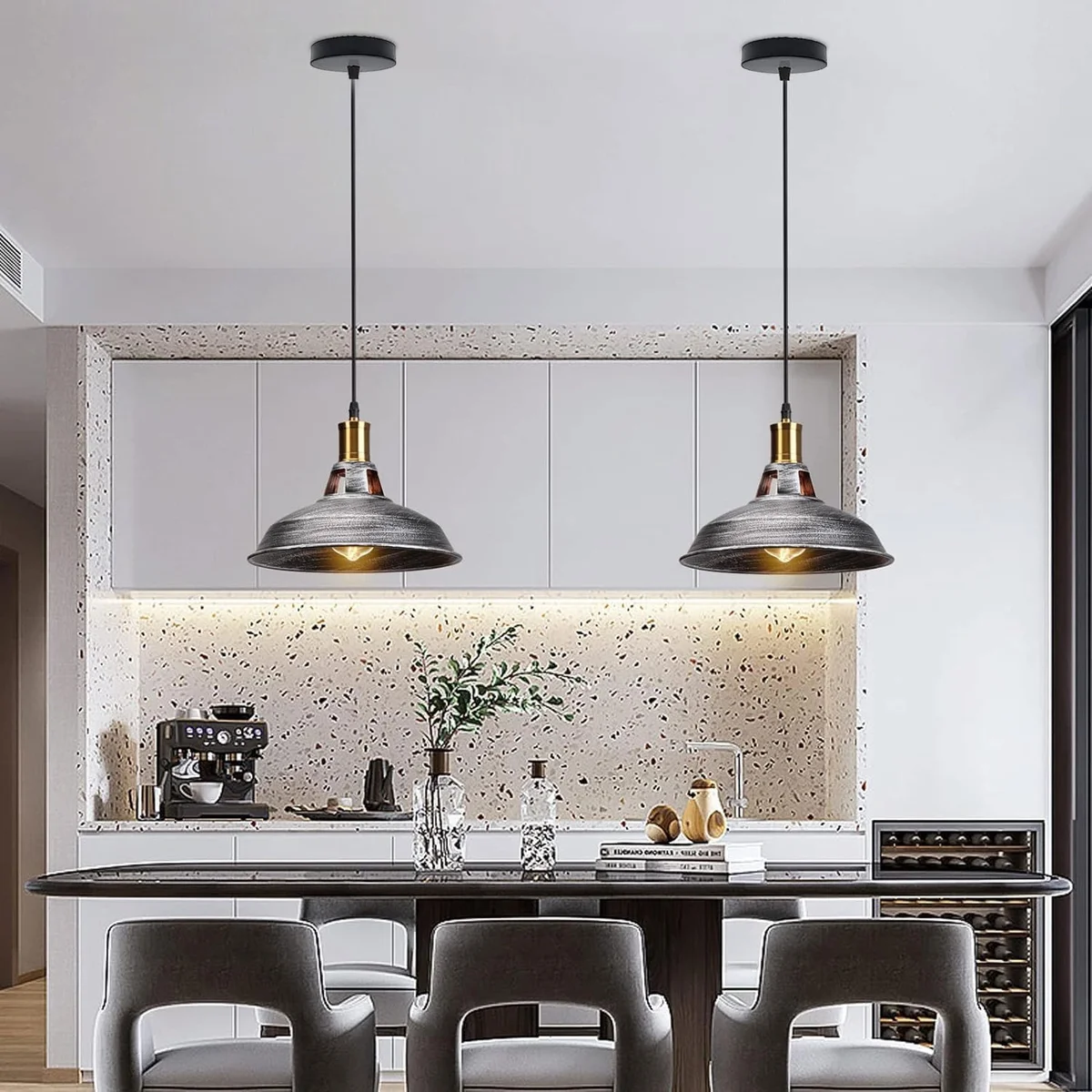 Three black metal retro industrial lamps hanging at different heights with adjustable cables in a bright interior setting
