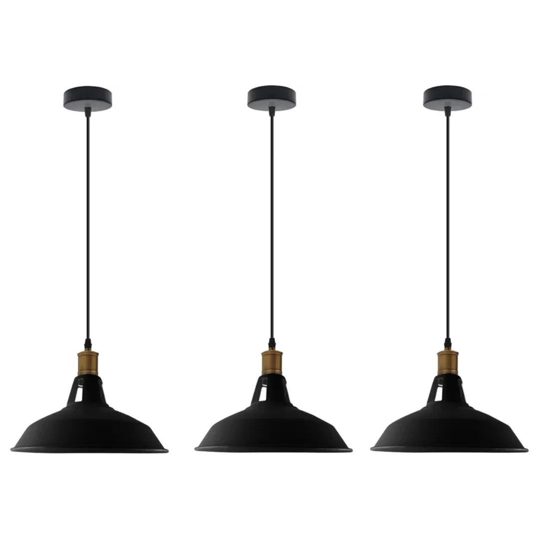 Three black metal industrial pendant lights with adjustable cables hanging over a wooden table in a modern kitchen setting