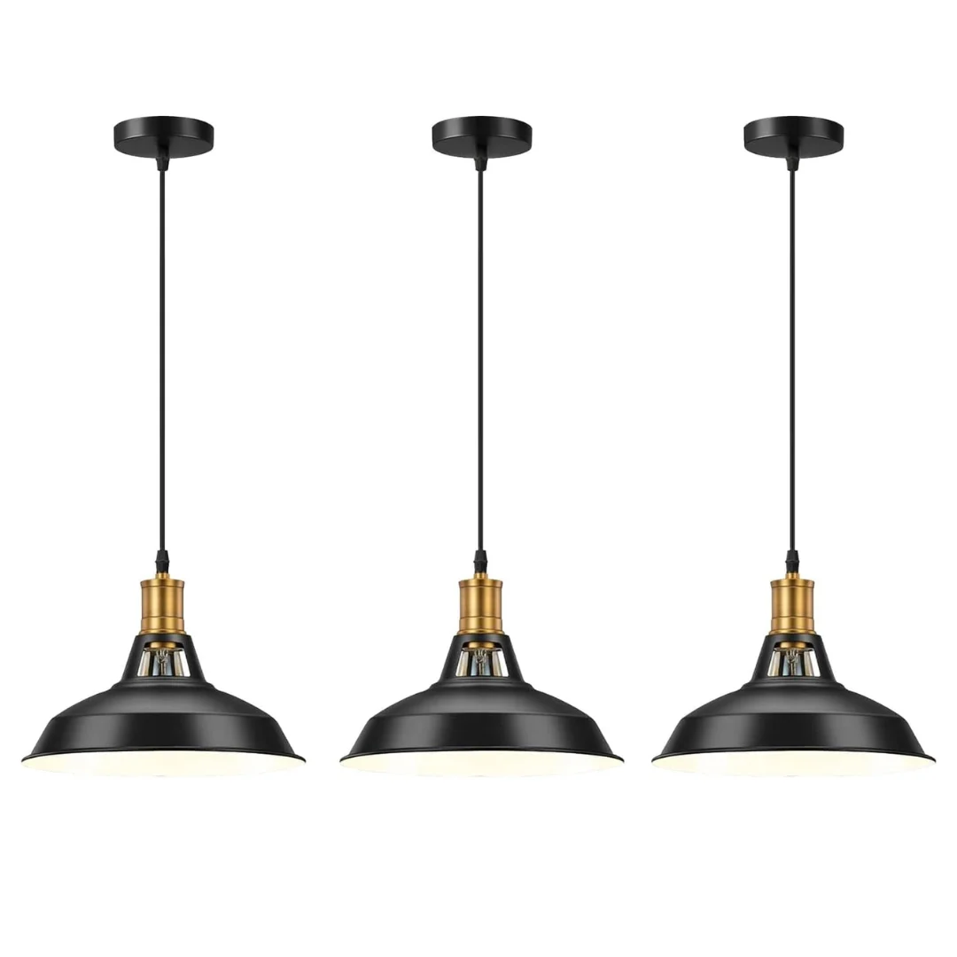Three black metal industrial pendant lights with adjustable cables hanging over a wooden table in a modern room setting