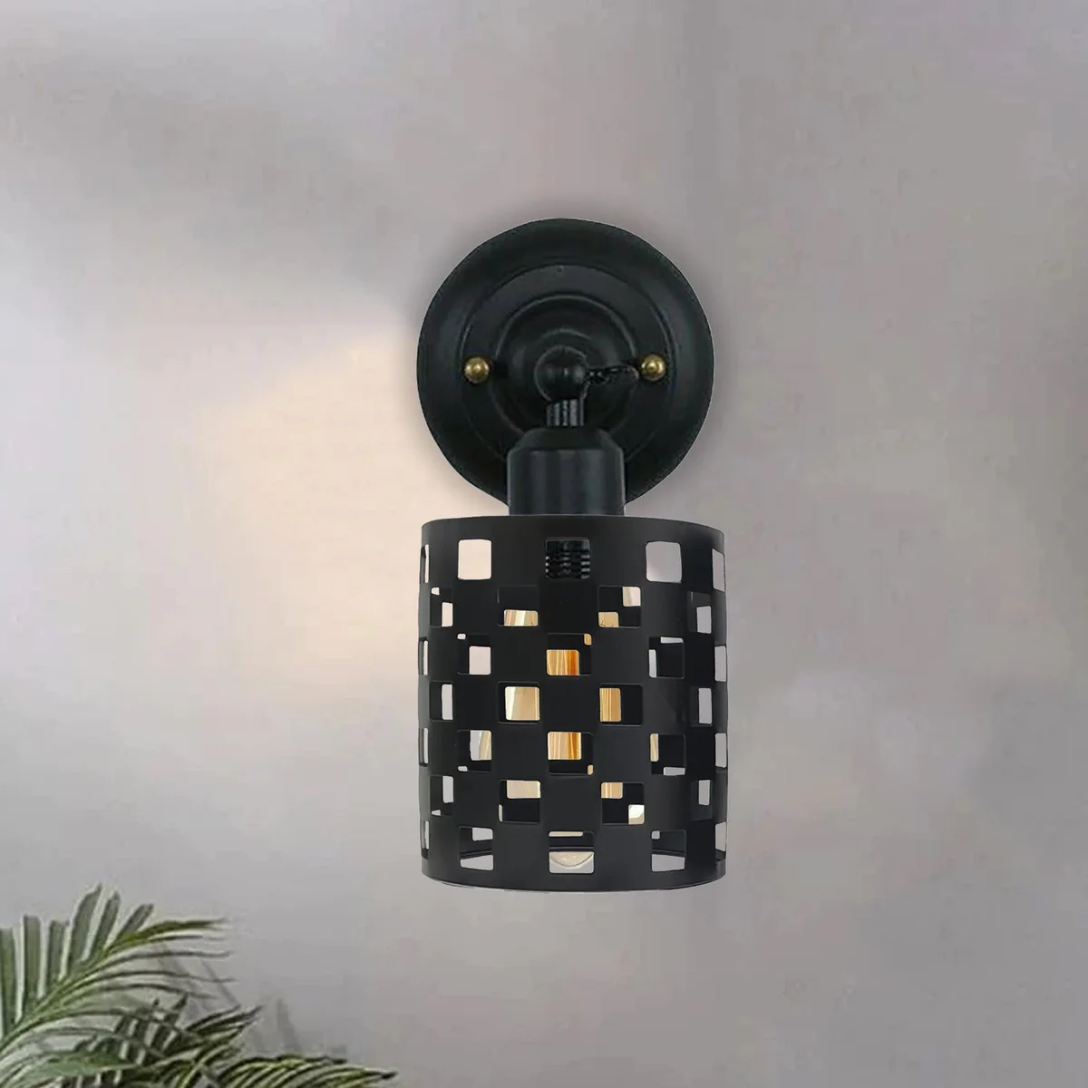 Black modern industrial wall sconce with adjustable arm and cylindrical shade mounted on a white wall background