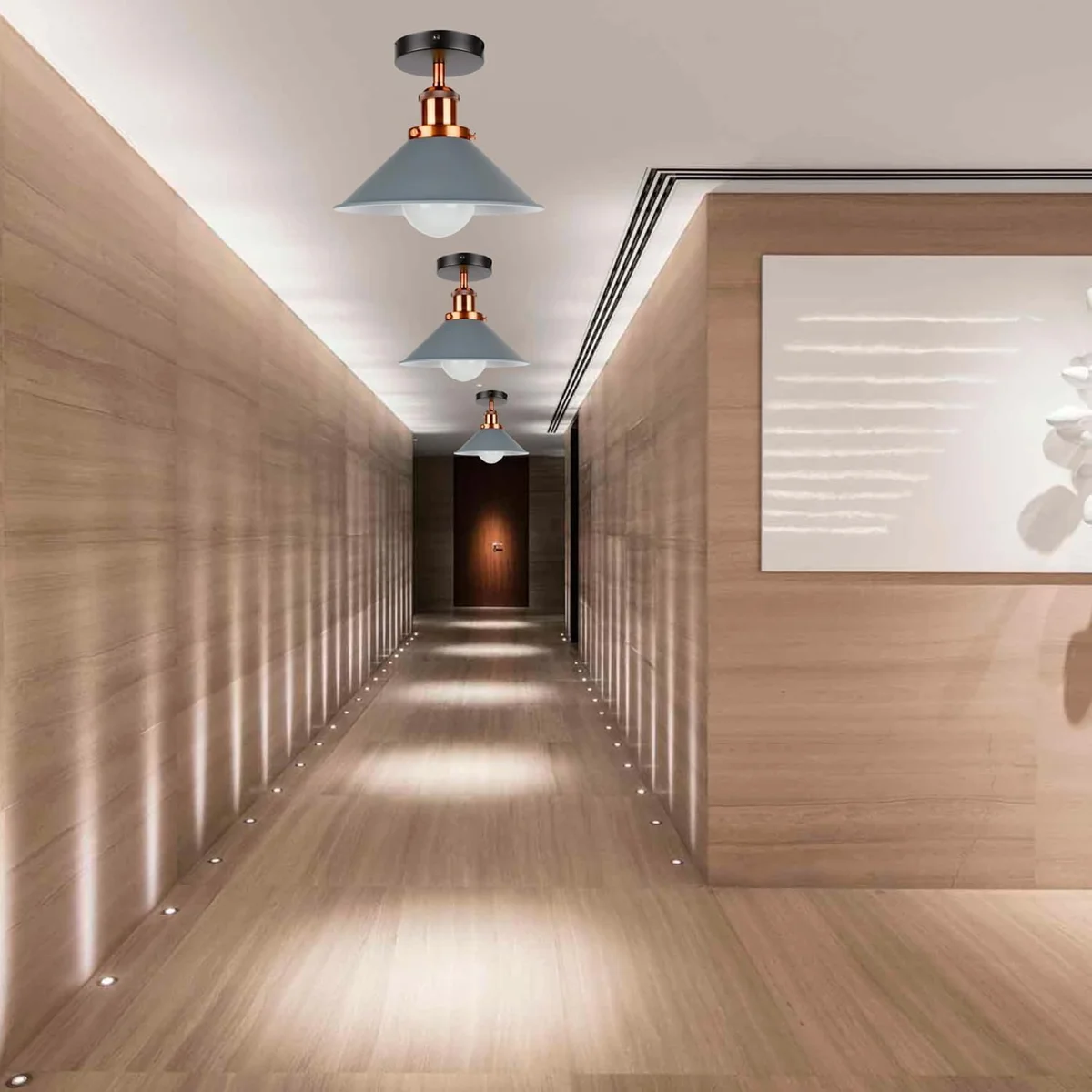 Two vintage pendant ceiling lights with metal cone shades in yellow brass and green finishes shown installed on a white ceiling