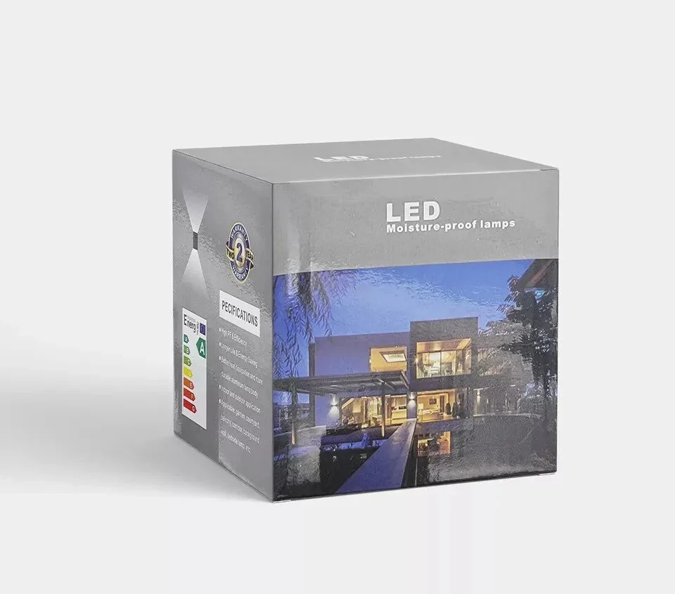 Two black square outdoor LED wall lights with motion sensors mounted on a white wall, emitting warm white light