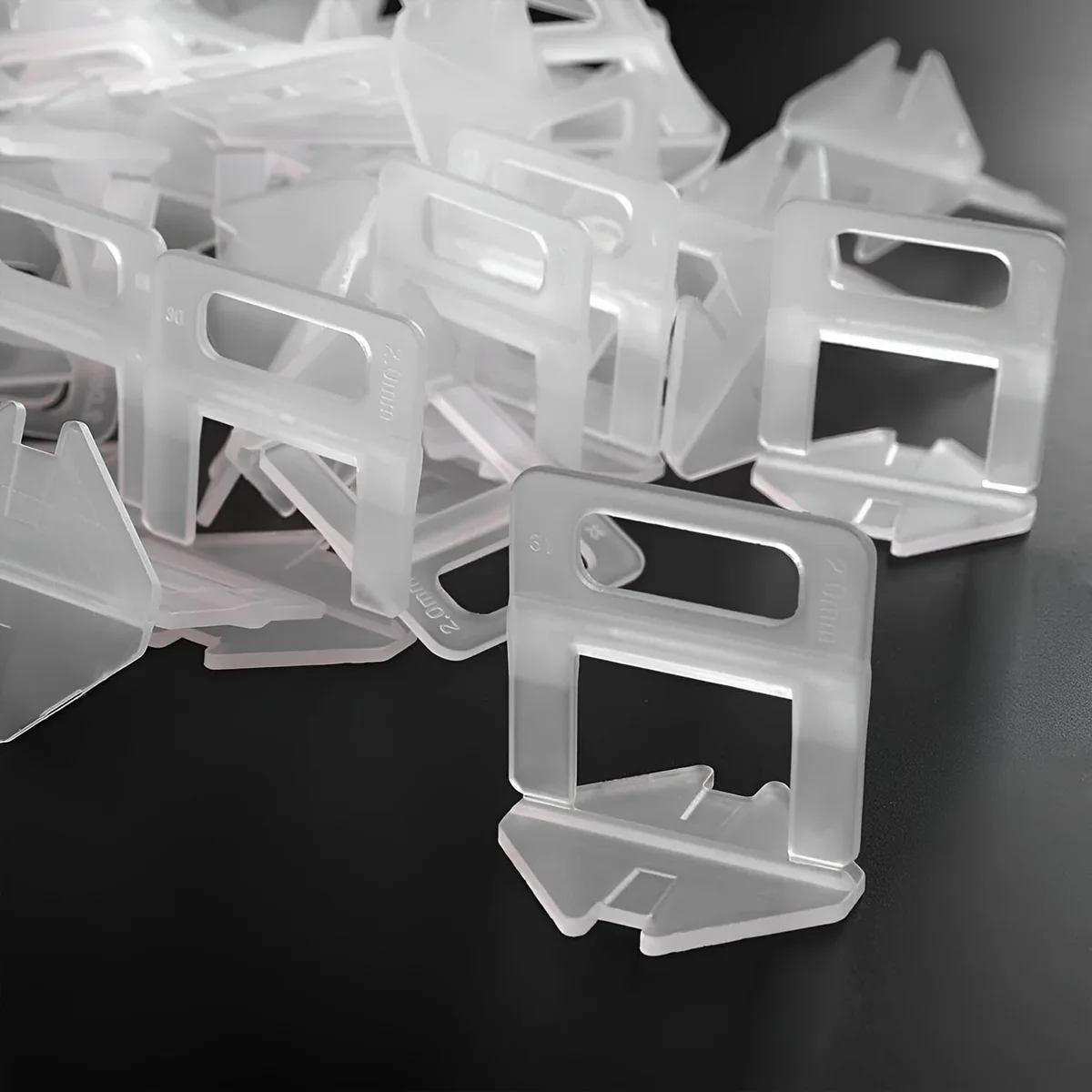 White X-shaped tile gap spacers made from durable plastic, arranged to show size and shape for tile leveling system