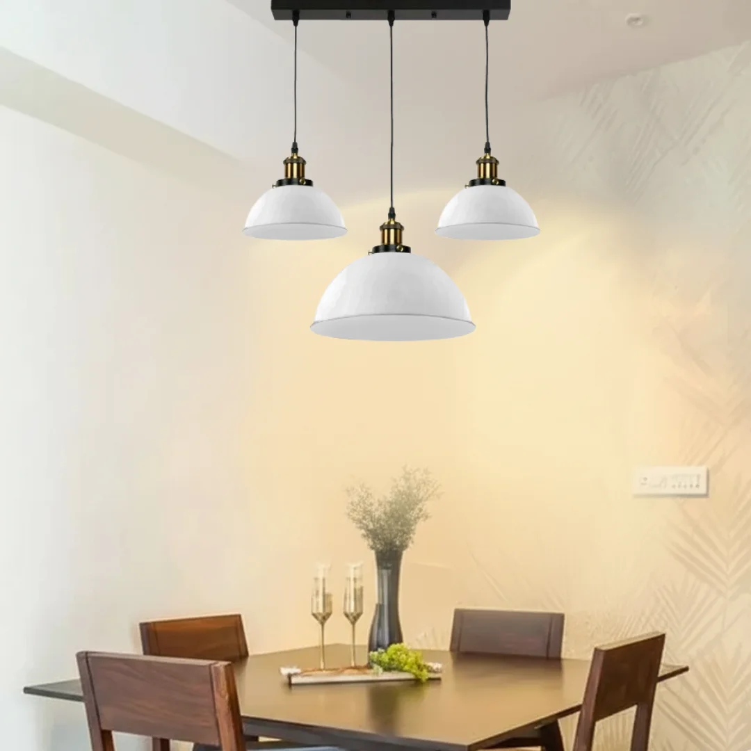 White modern pendant light with three dome-shaped metal shades hanging from ceiling rose