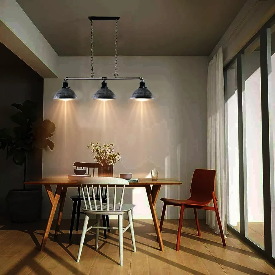 Vintage pendant ceiling light with black metal pipe frame, three cup lamps, suspended over dining table, industrial design.