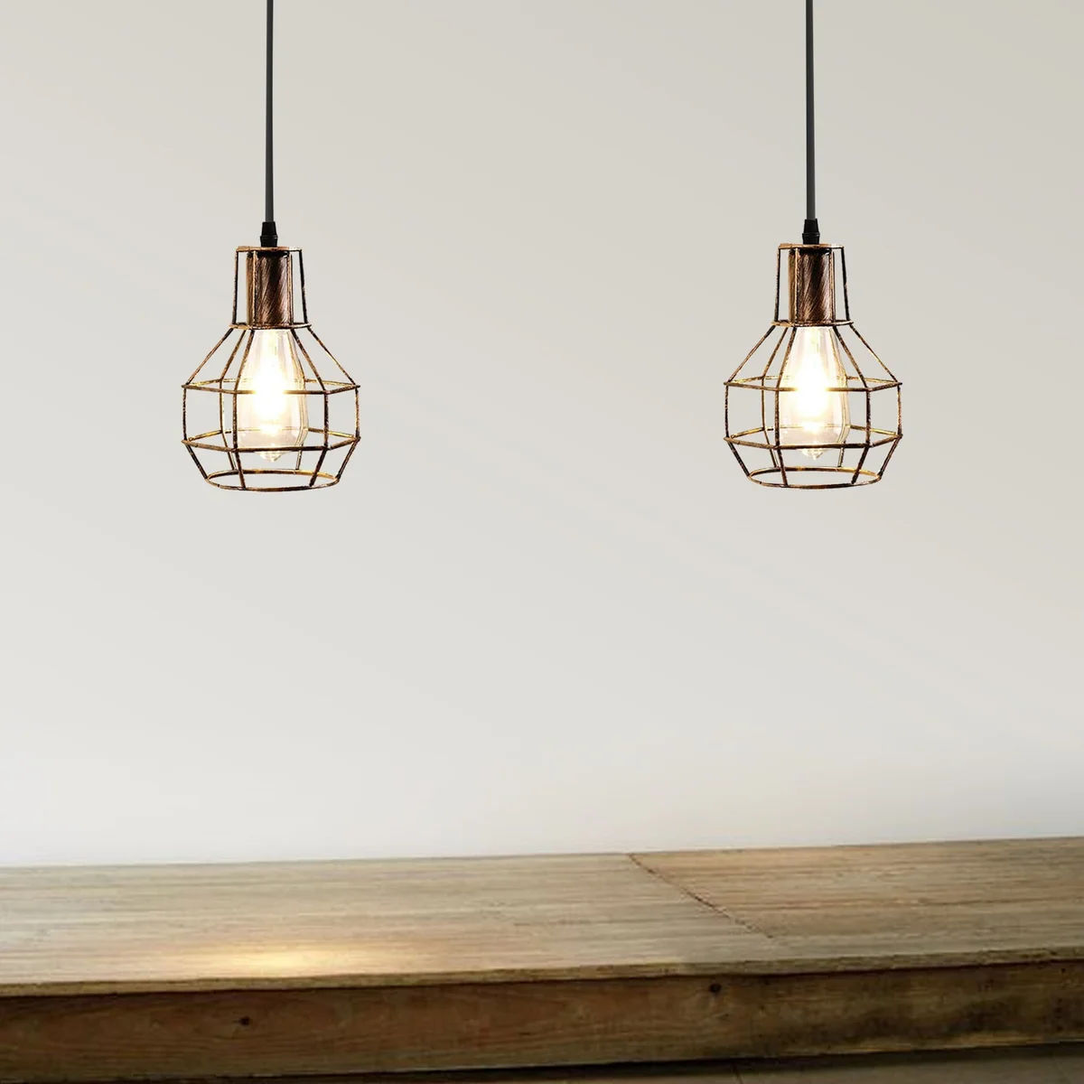Industrial multi-head pendant lighting with black hexagonal wire cages and adjustable cables hanging from ceiling rose