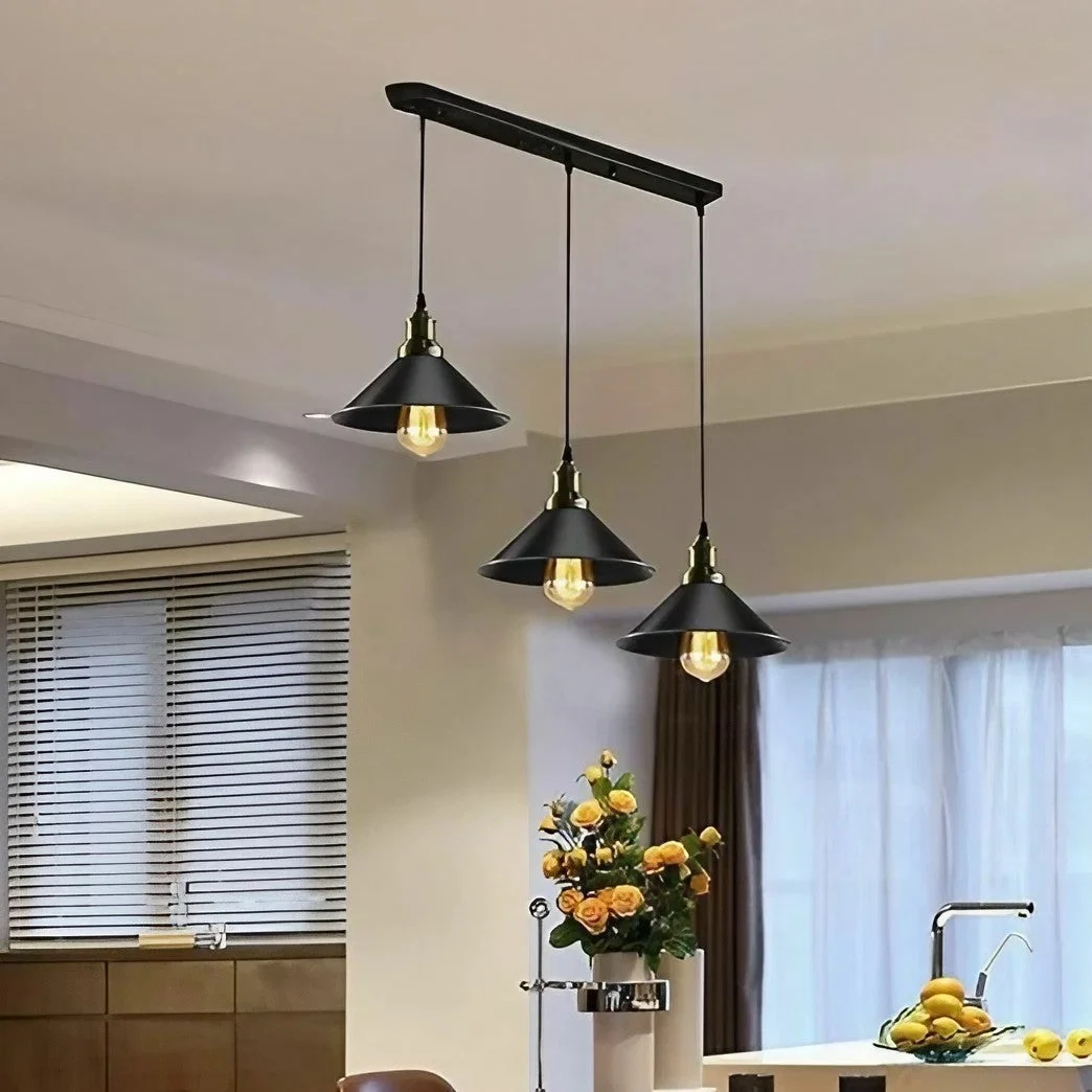 Black industrial pendant light with three adjustable hanging lights and metal shades over dining table