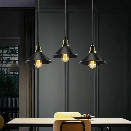 Three black metal shades on an adjustable hanging light with cables hanging at varying lengths against a white background