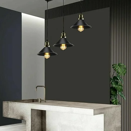Three black metal pendant lights with industrial design hanging at adjustable heights over a dining table