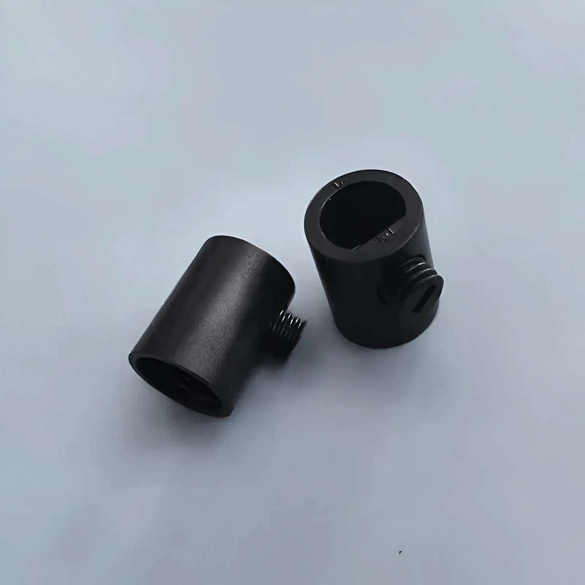 Five black M10 plastic pendant light grips with side screws arranged on a white background for electrical use