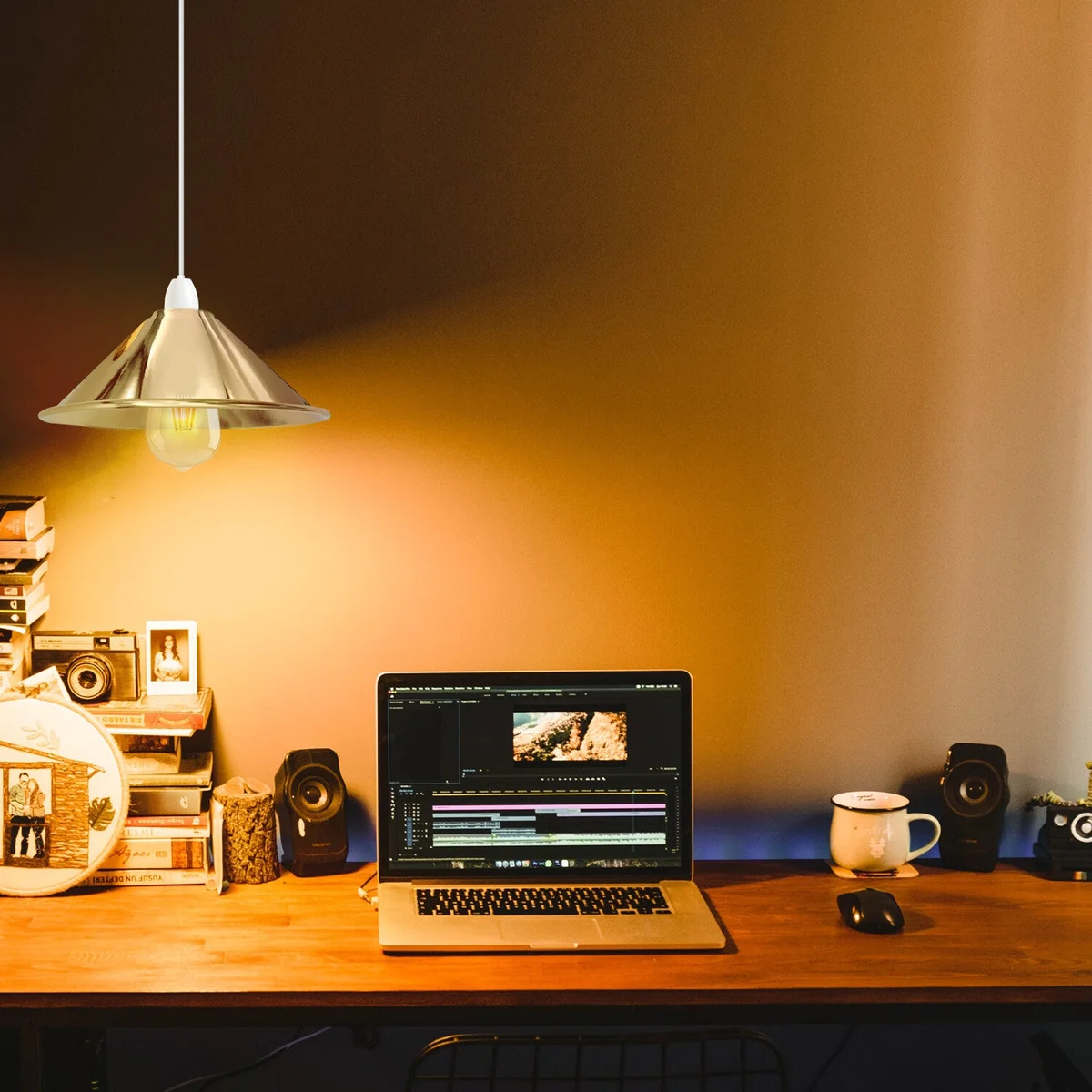 French gold industrial metal easy fit lamp shade shown mounted on a wall with warm light glowing inside