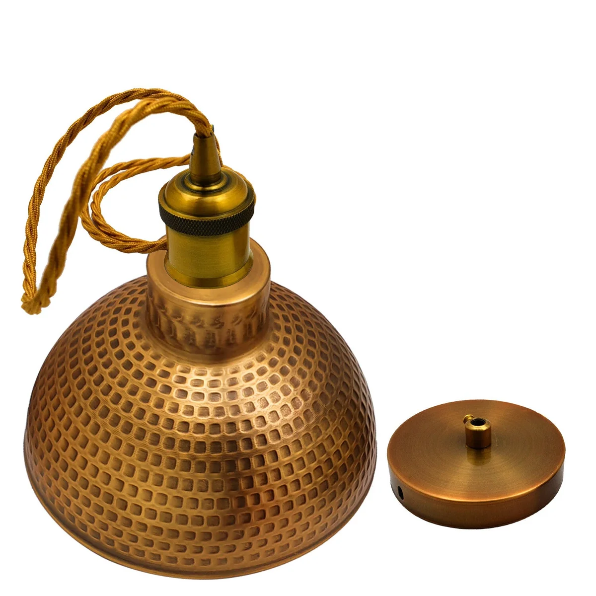 Vintage brass pendant light with hammered dome shade hanging above a wooden dining table in a modern kitchen setting