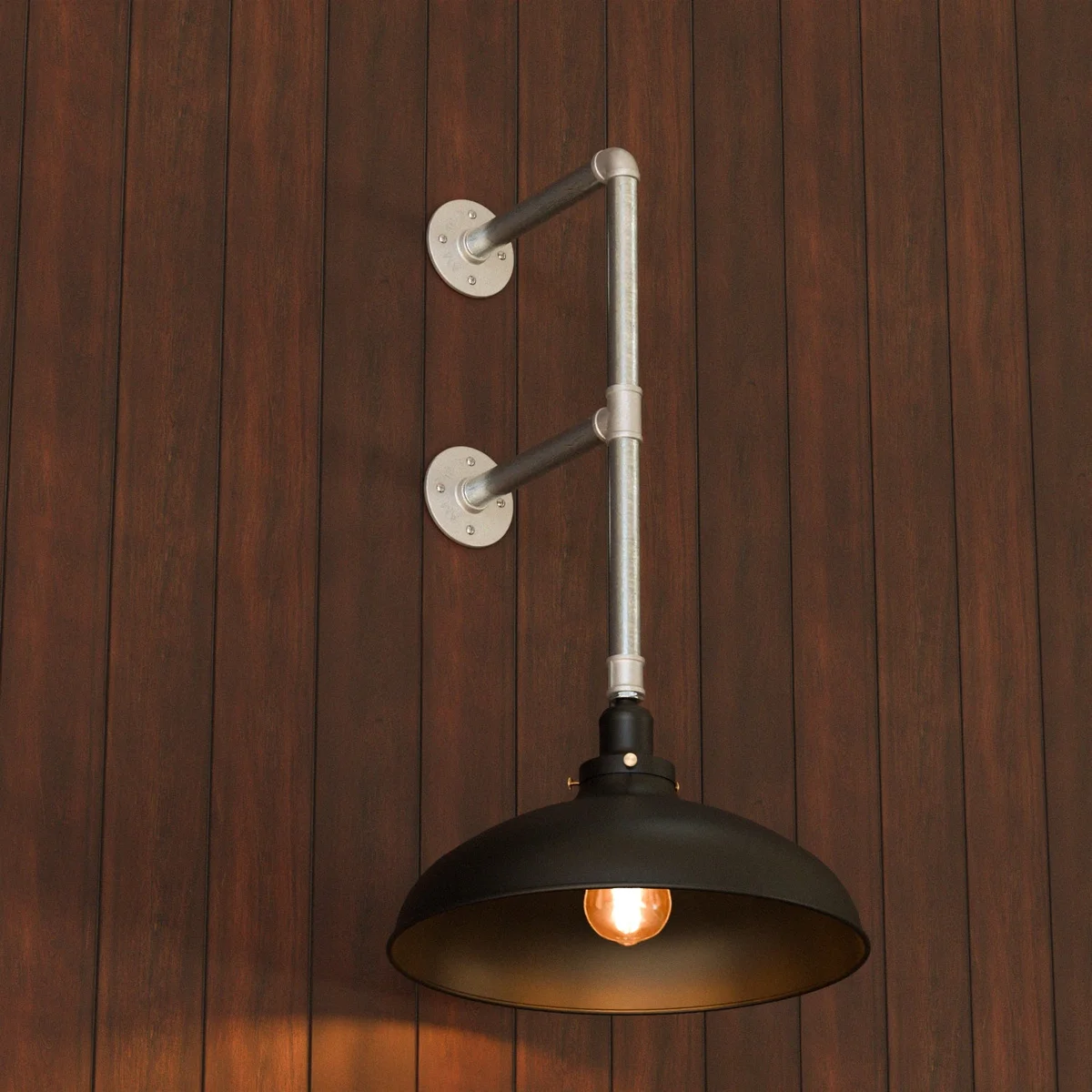 Industrial pipe wall lamp with dual flange mounts, matte black dome shade, and galvanized metal finish on white wall