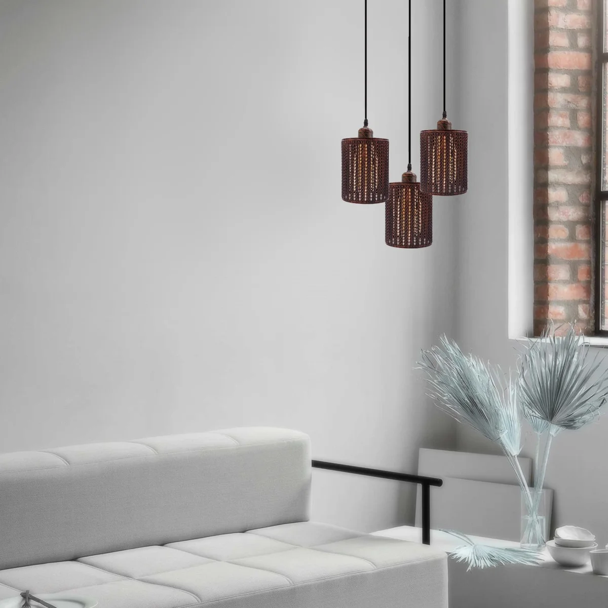 Industrial ceiling pendant with three rustic red metal cage shades and adjustable cables hanging against white background