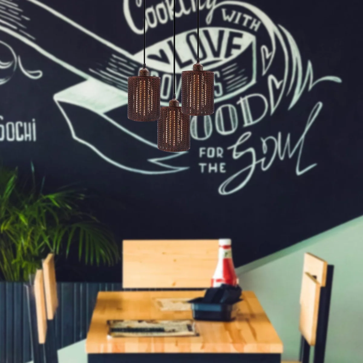 Three vintage red metal barrel cage pendant lights with adjustable cables hanging against a white background