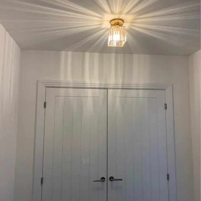 Two small square crystal ceiling lights with metal cage design mounted flush on a white ceiling, showing crystal details.