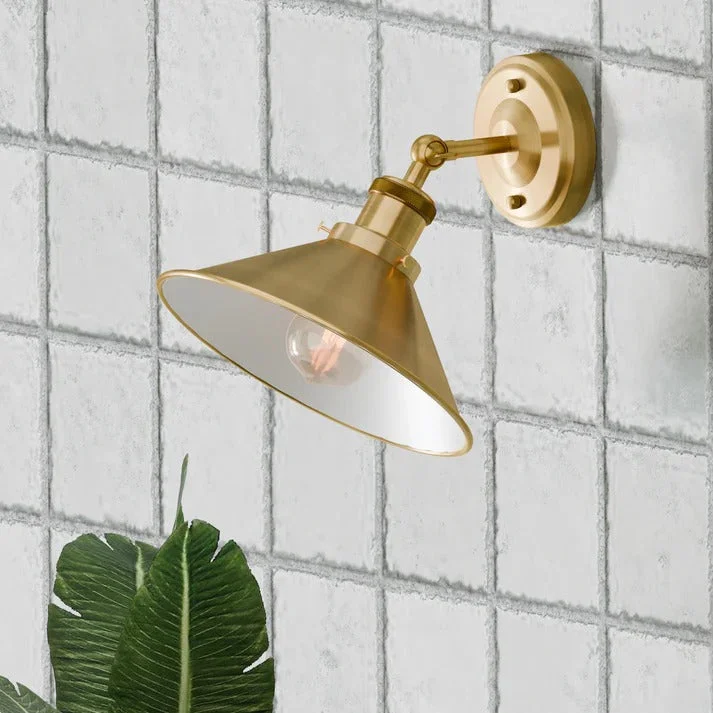 Industrial metal sconce lamp with adjustable arm and vintage painted finish mounted on a wall indoors