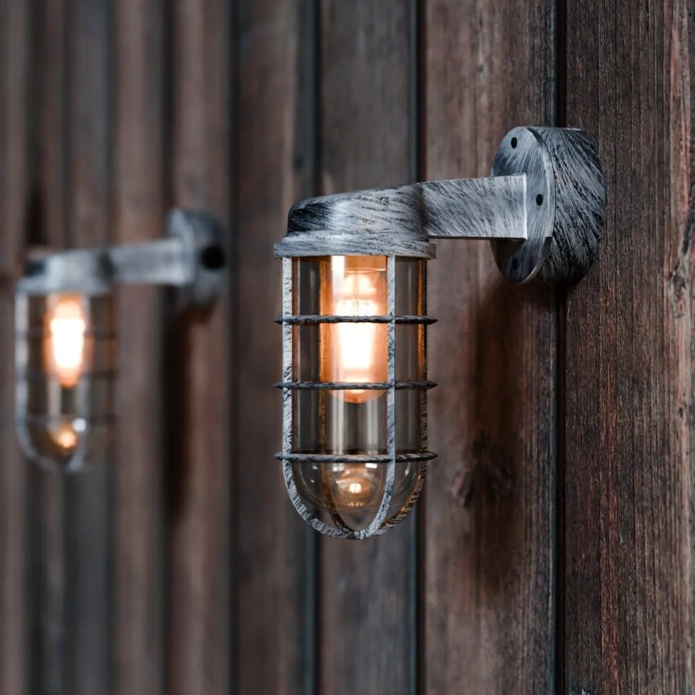 Vintage industrial cage wall light with metal protective cage and frosted glass cover mounted on white wall