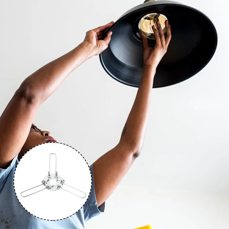 Circular metal lamp shade spring clip with three wire arms, designed to secure and support lamp shades