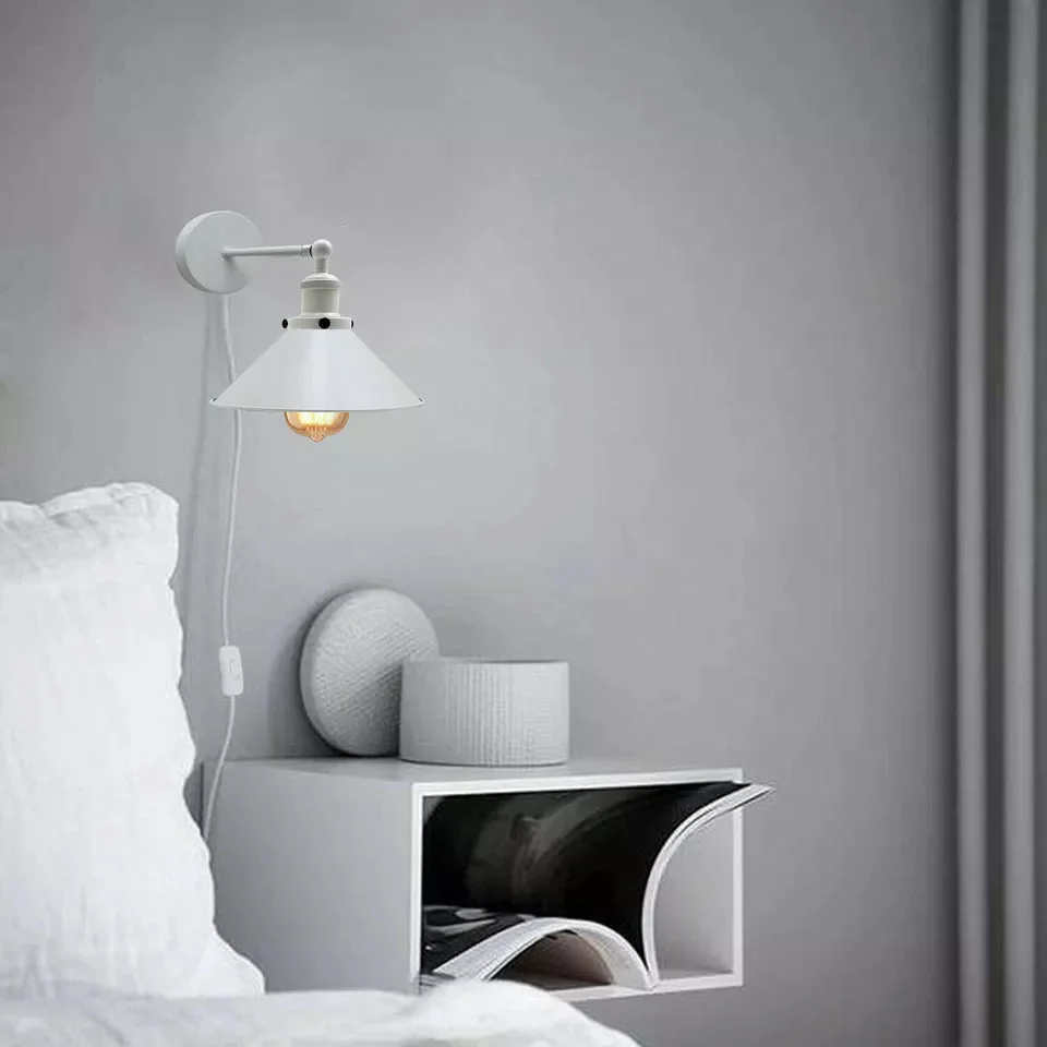 Modern metal bedside wall lights with plug-in cable and dimmer switch mounted on a white indoor wall