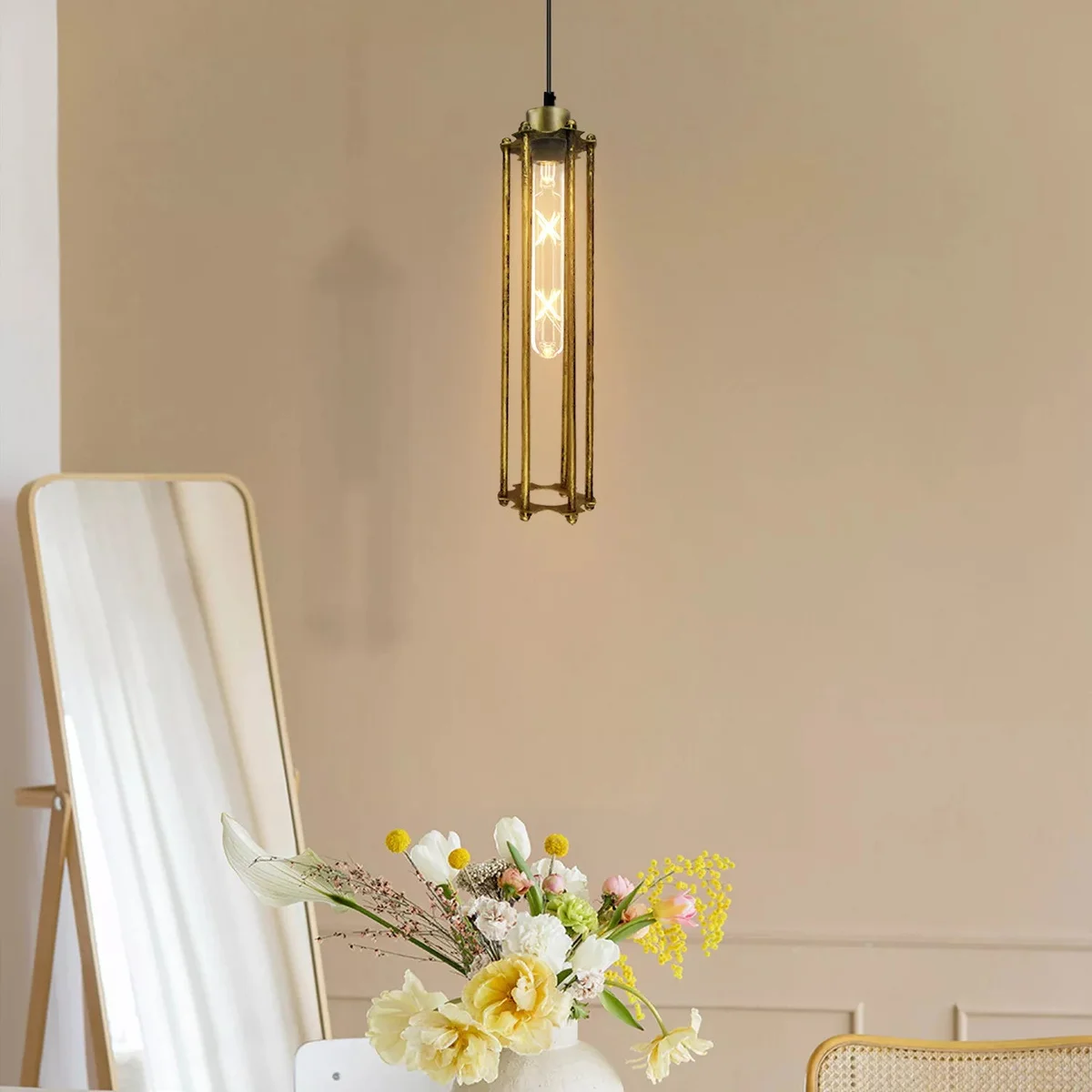 Brushed brass industrial height adjustable pendant light with tube-shaped metal shade and warm white LED bulb hanging indoors