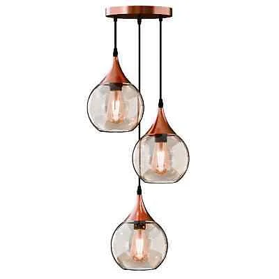 Three-light amber glass metal and glass chandelier with copper finish and adjustable cords hanging indoors