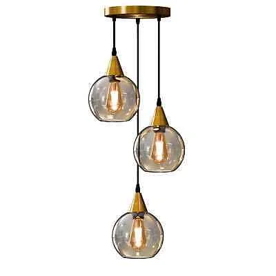 Three-light amber glass pendant with copper finish, adjustable cords, warm ambient ceiling light for dining spaces