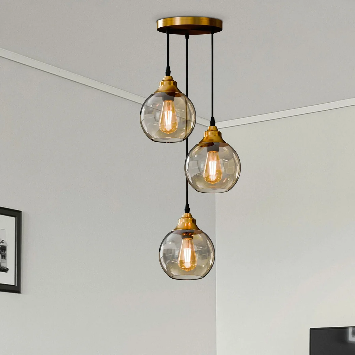 Three-light modern glass pendant light with teardrop glass shades and warm copper finish hanging indoors