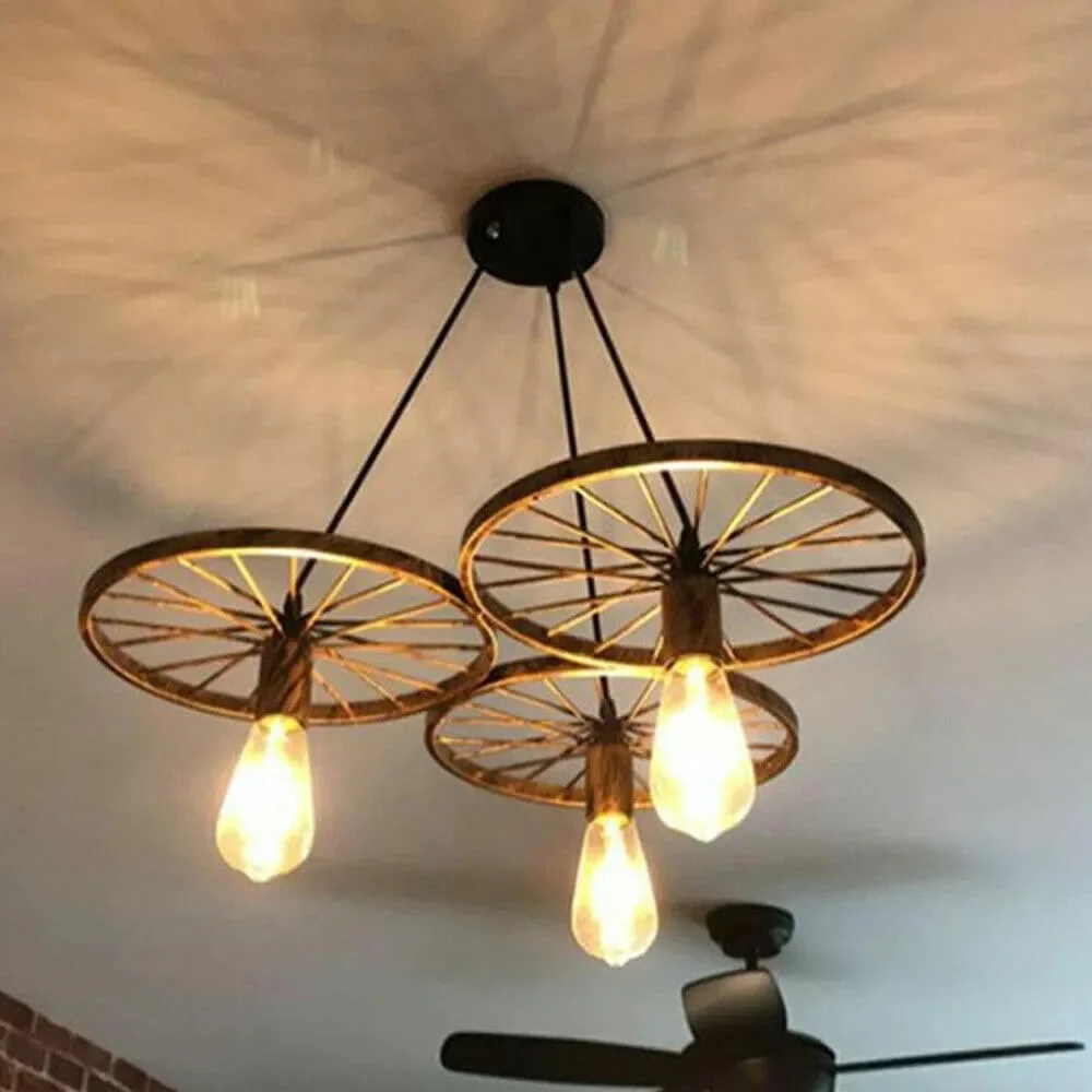 Rustic wagon wheel pendant with three Edison bulbs, showcasing industrial style lighting for dining or kitchen spaces