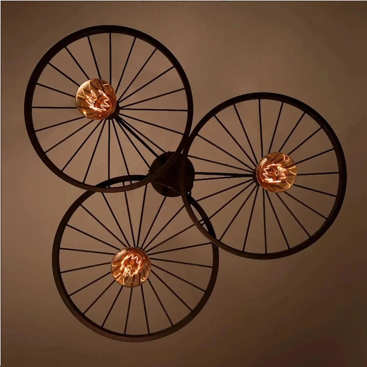 Rustic industrial pendant light with wagon wheel design and three Edison bulbs hanging from ceiling fixture
