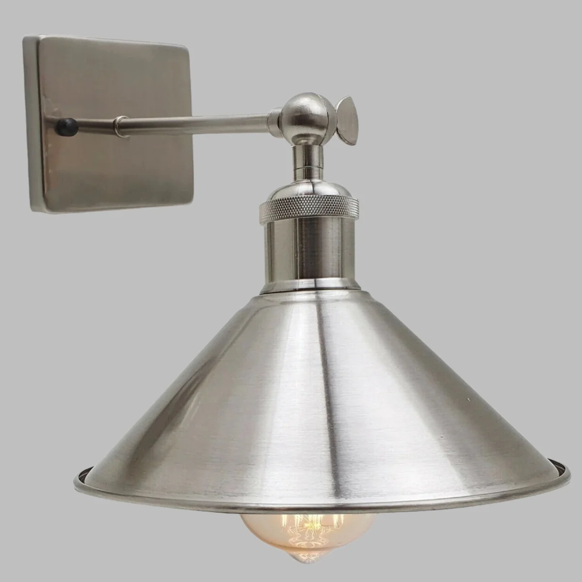 Adjustable wall lamp with satin nickel metal shade, 10cm square, fitted on wall with articulated arm.
