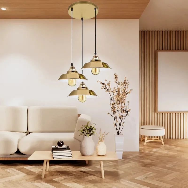 Three yellow brass vintage cluster pendant light with adjustable cables and retro metal shades hanging indoors
