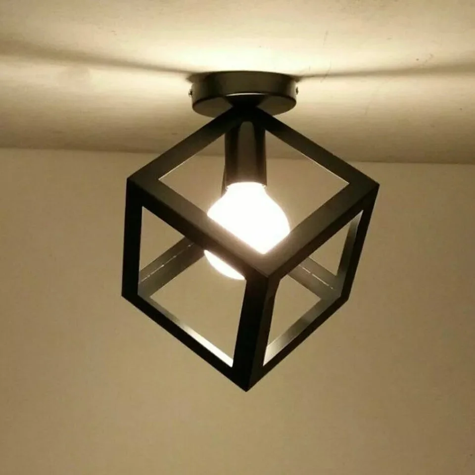 Black industrial ceiling light with geometric metal cage flush mount and included bulb against white background