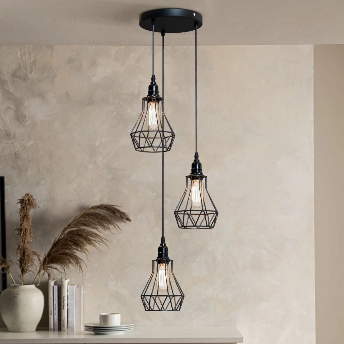 Black industrial pendant light with geometric metal cage and in-line switch hanging from adjustable cable