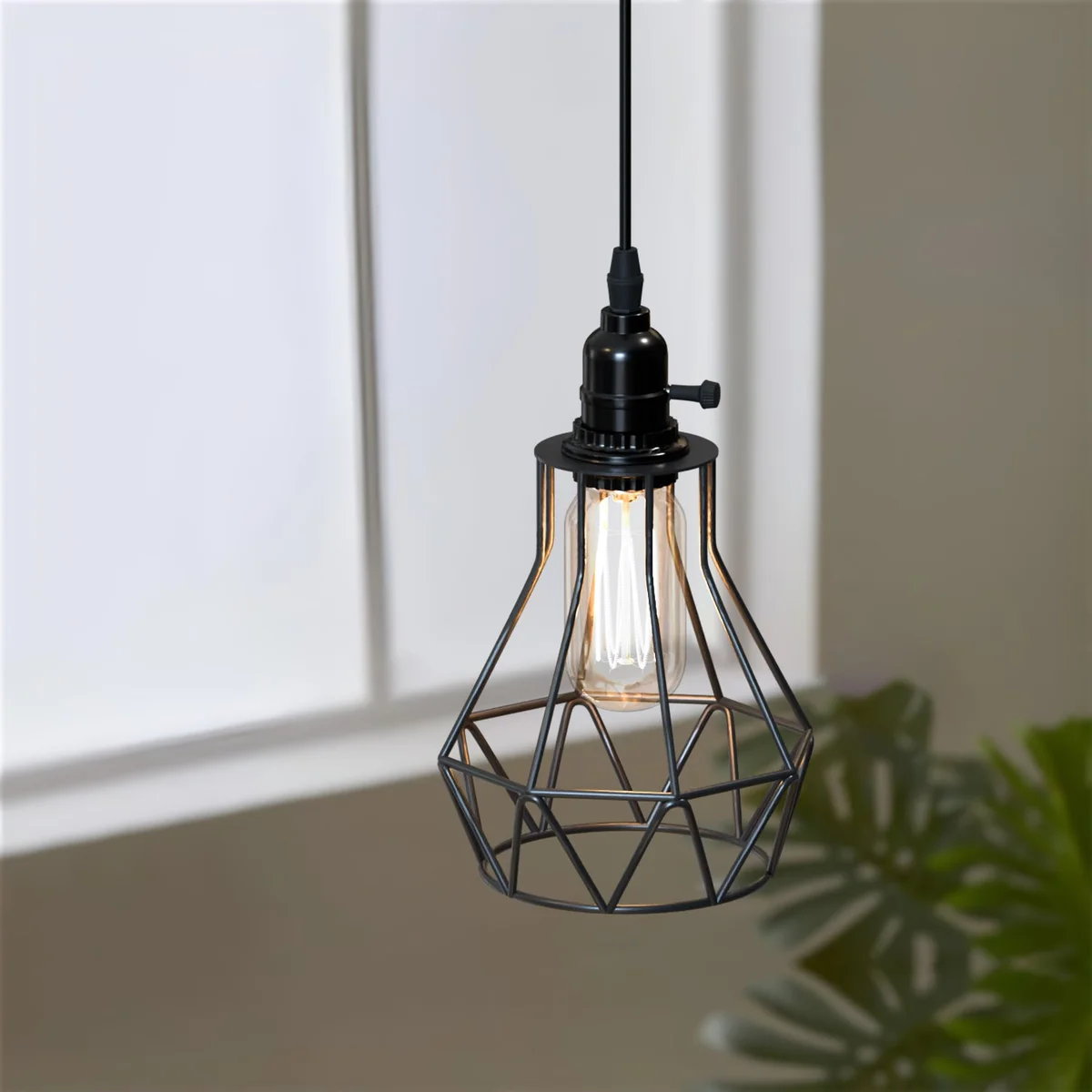 Black industrial pendant light with geometric metal cage and in-line switch hanging over wooden dining table