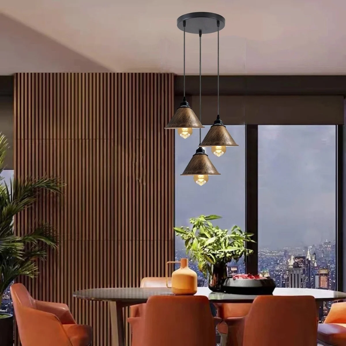 Three brushed copper industrial pendant light shades with black holders and adjustable cables hanging from a ceiling rose