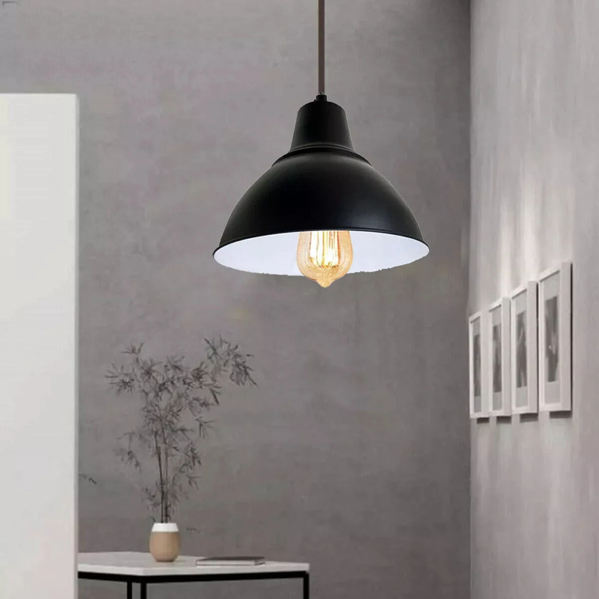 Black metal industrial pendant light with barn style shade and adjustable chain hanging from ceiling fixture