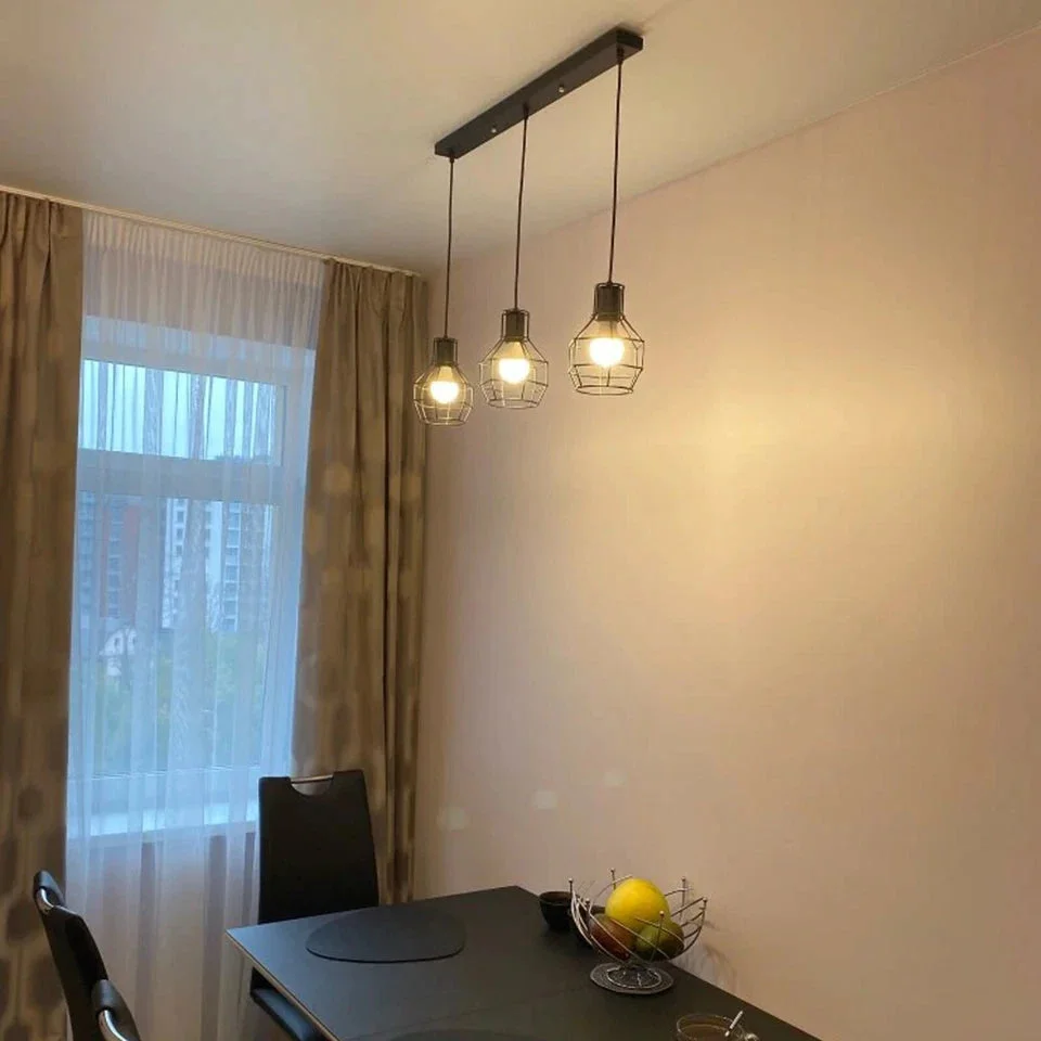 Black vintage industrial pendant light with three metal cages and 90cm cables hanging from ceiling plate