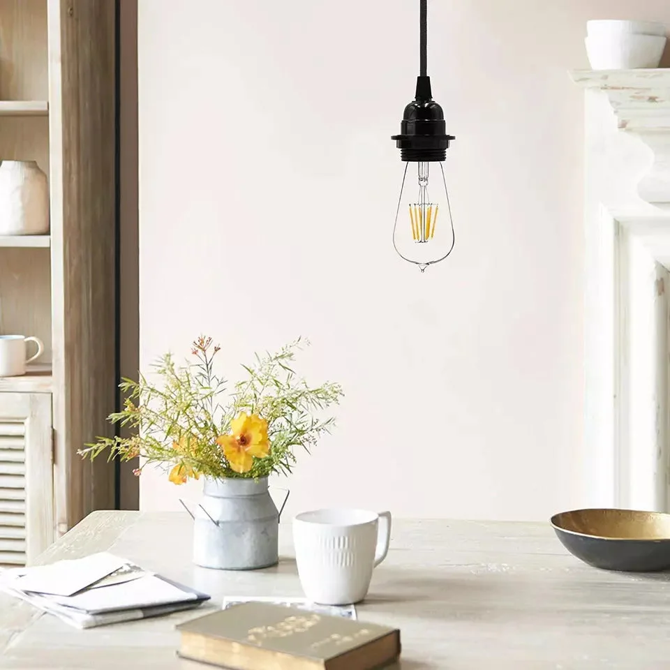 Black twin pendant light with two adjustable matte black metal heads and fabric cables hanging from ceiling rose