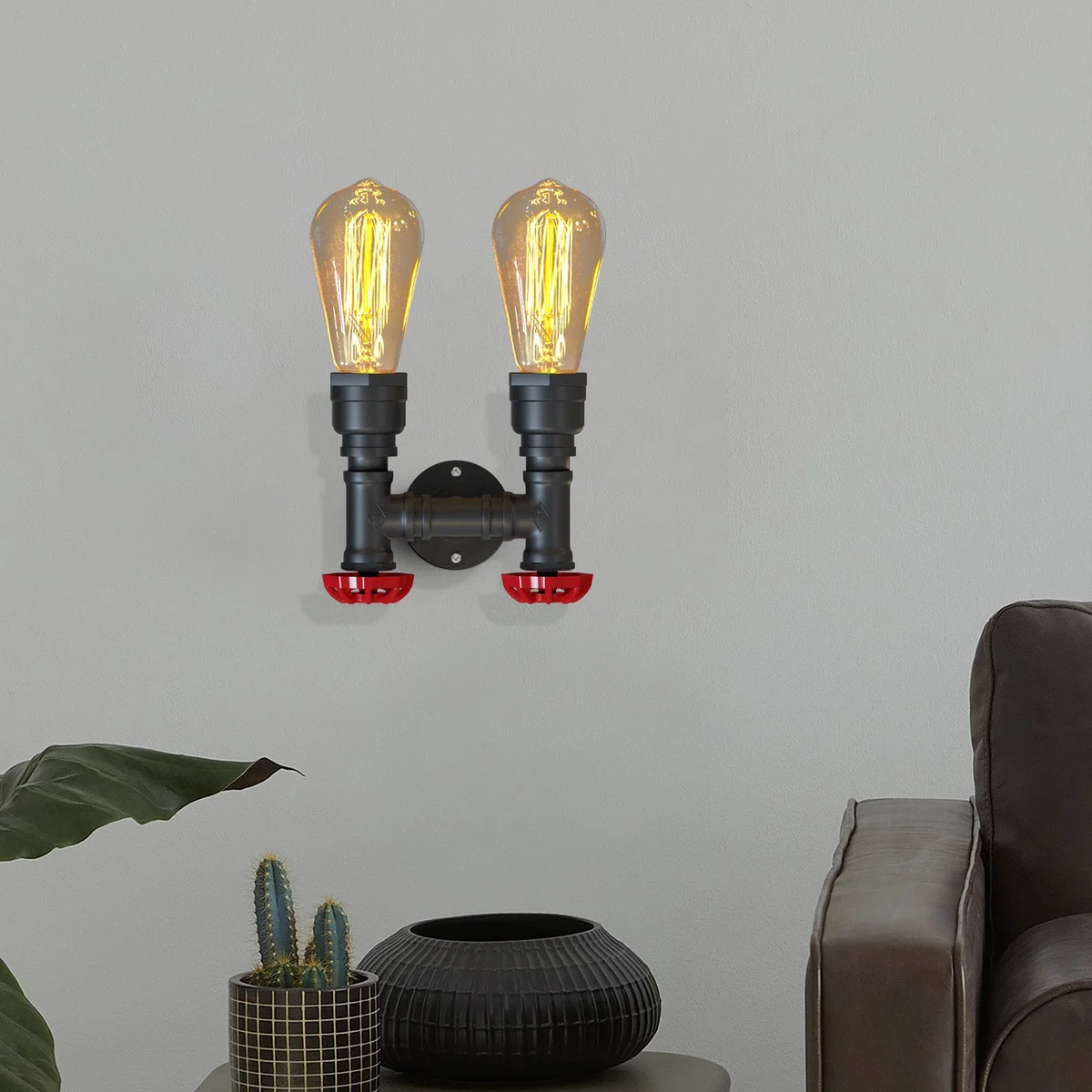Twin steampunk wall light with dual black metal pipes and red valve details mounted on a white wall background