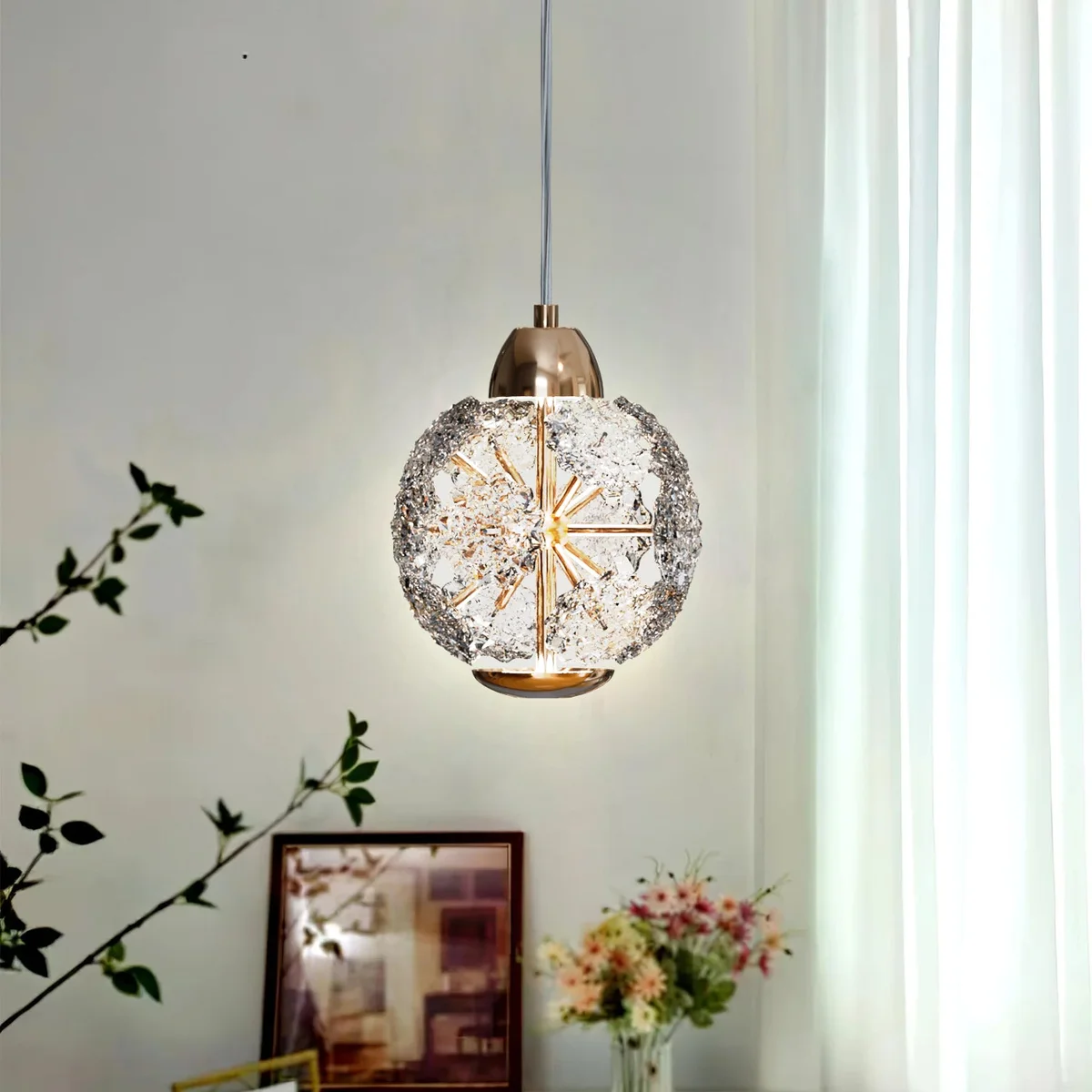 Modern pendant light with round amber textured crystal glass shade hanging from adjustable metal and PVC cable