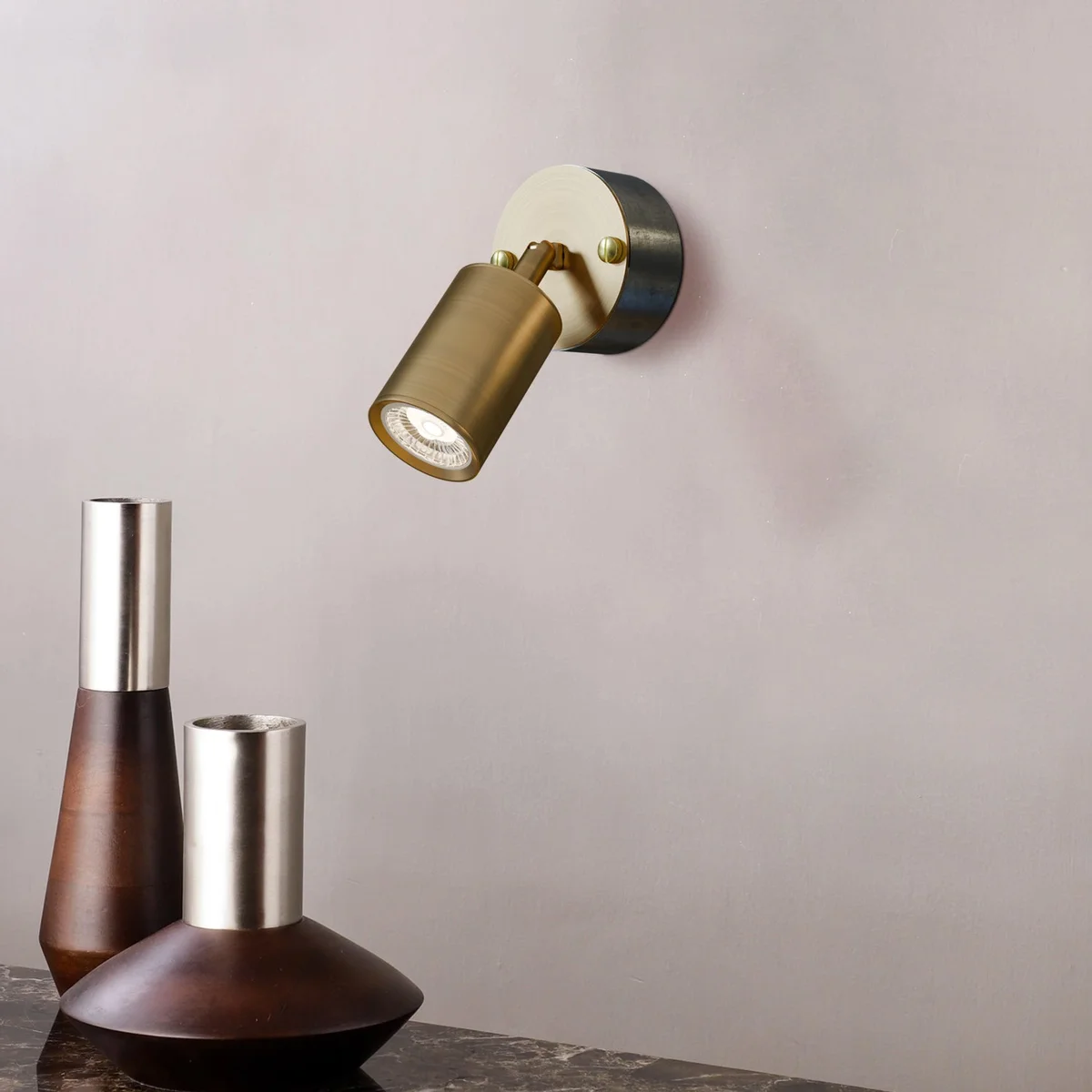 Rotatable yellow brass GU10 spotlight with cylindrical metal body and 20mm galvanized steel conduit loop-in box mounted on wall